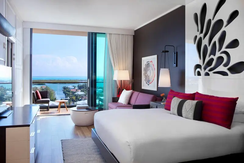 Une chambre lumineuse avec un grand lit et une vue sur la mer.