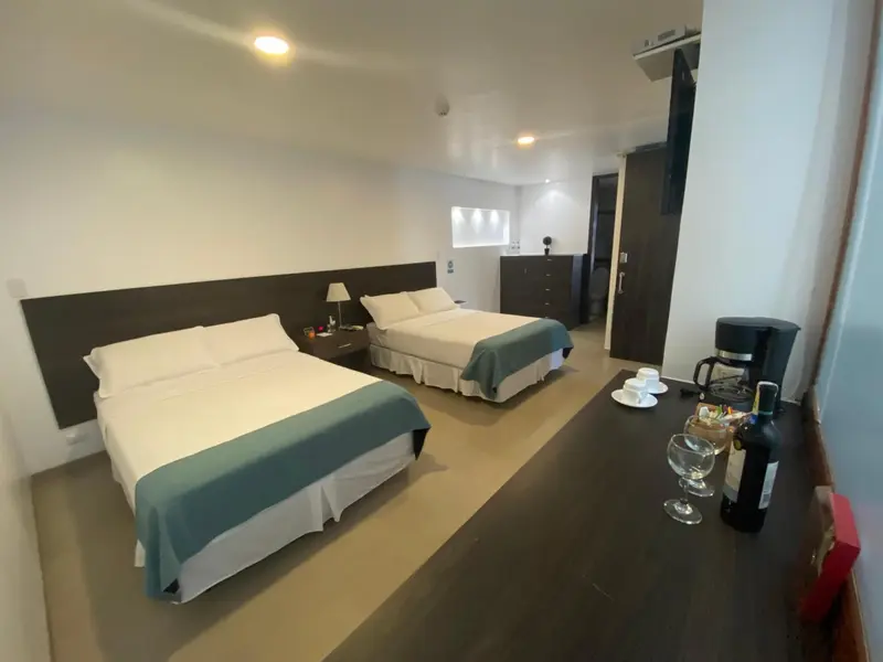 Une chambre lumineuse avec deux lits simples et un coin salon.