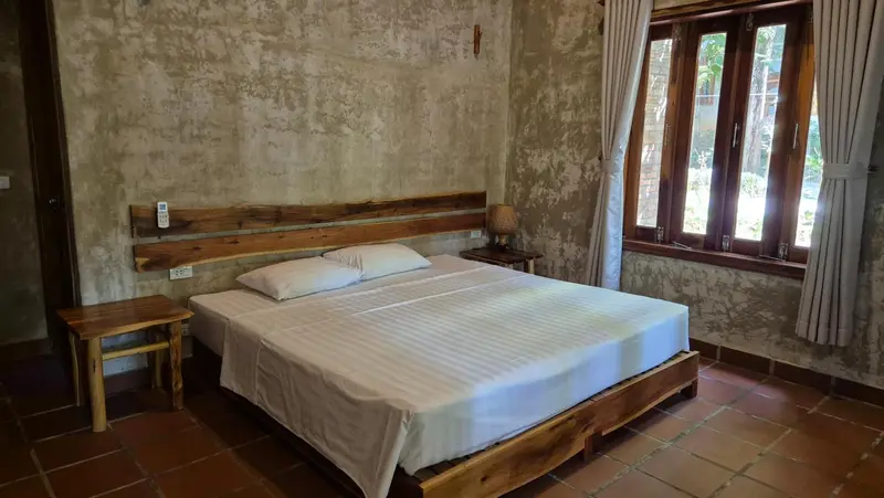 Une chambre lumineuse avec un lit recouvert d'une literie blanche et un mobilier en bois.