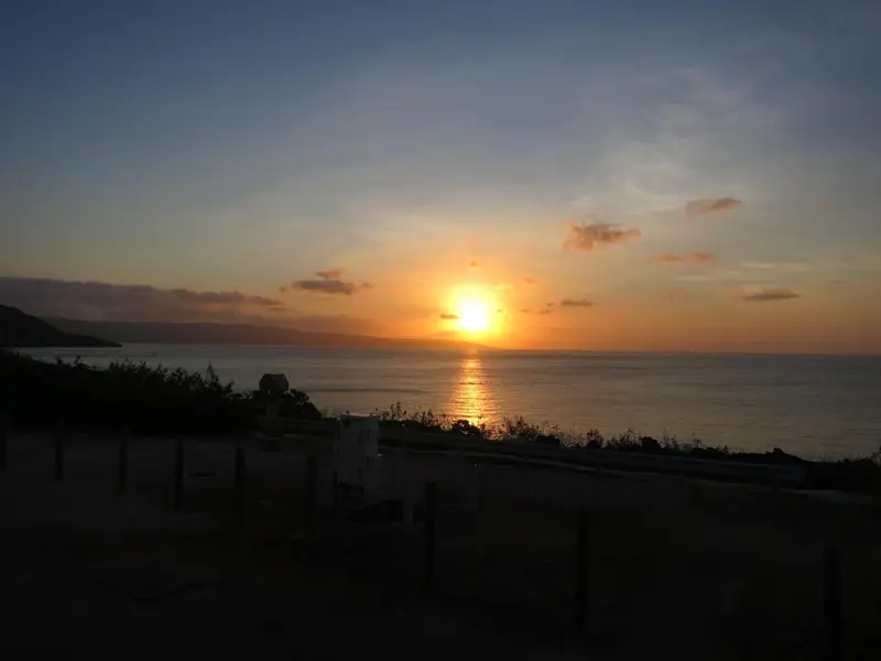 Coucher de soleil sur l'océan avec une vue sur la côte.