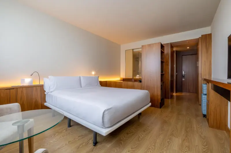 Une chambre lumineuse avec un grand lit et un mobilier en bois.