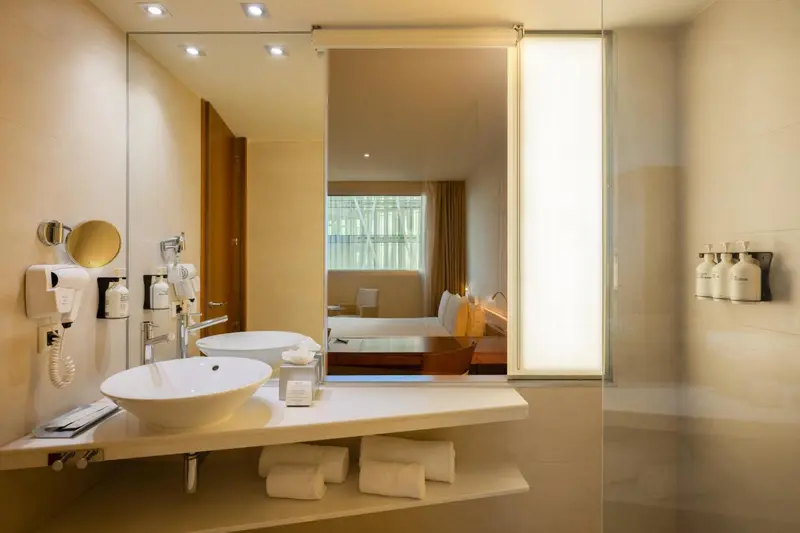 Une salle de bain moderne avec un lavabo et un grand miroir.