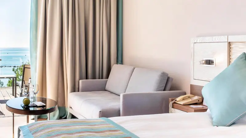 Une chambre lumineuse avec un canapé et un lit.