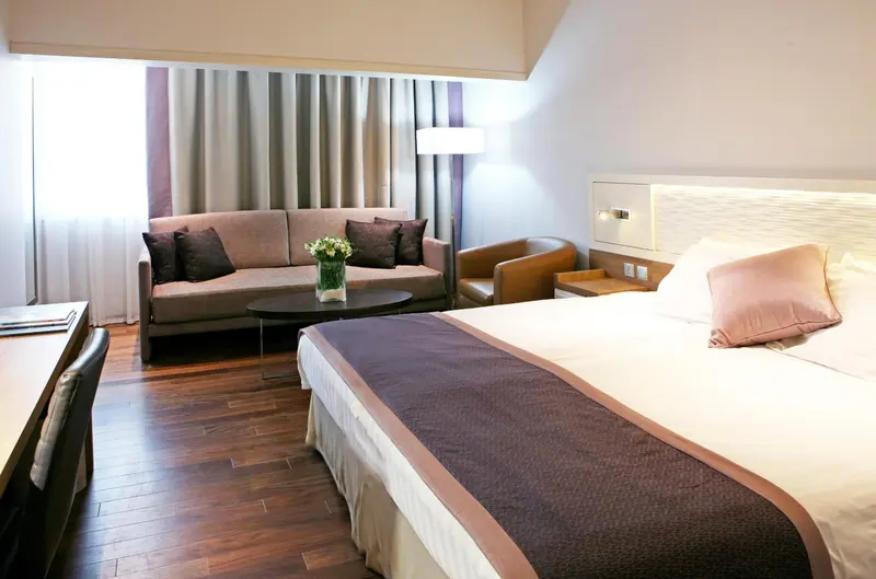Une chambre lumineuse avec un lit double et un espace salon.