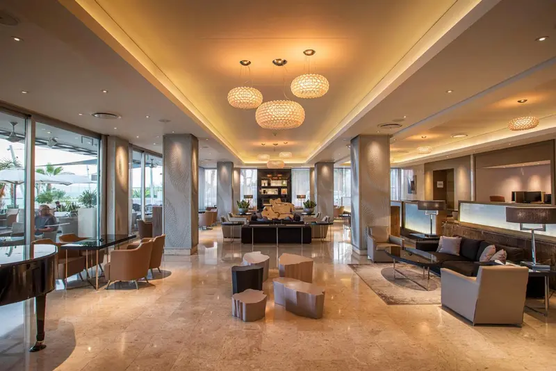 Vaste espace de réception lumineux avec des canapés et des fauteuils confortables.