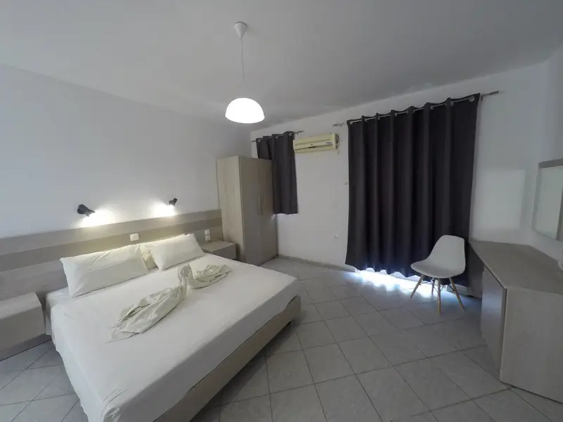 Une chambre lumineuse avec un grand lit et un coin salon.
