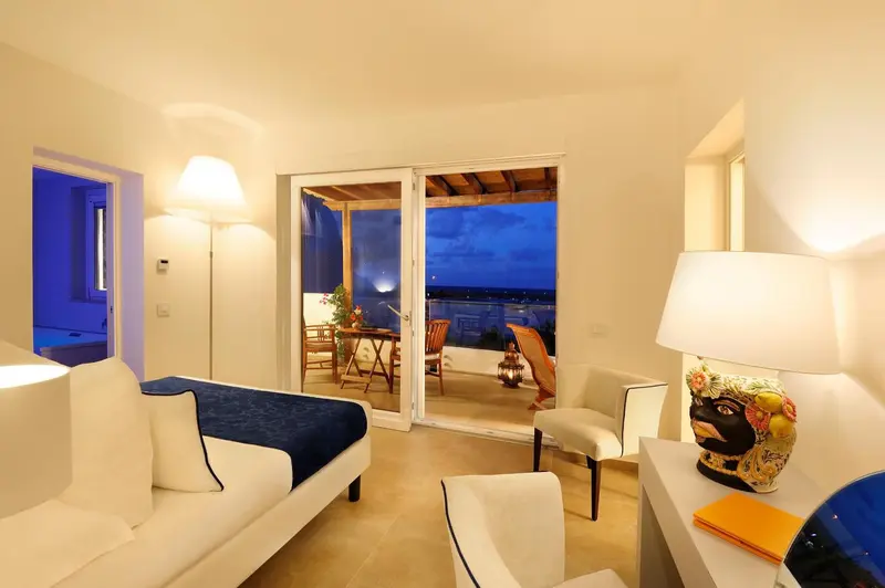 Espace de détente lumineux avec canapés et accès à une terrasse.