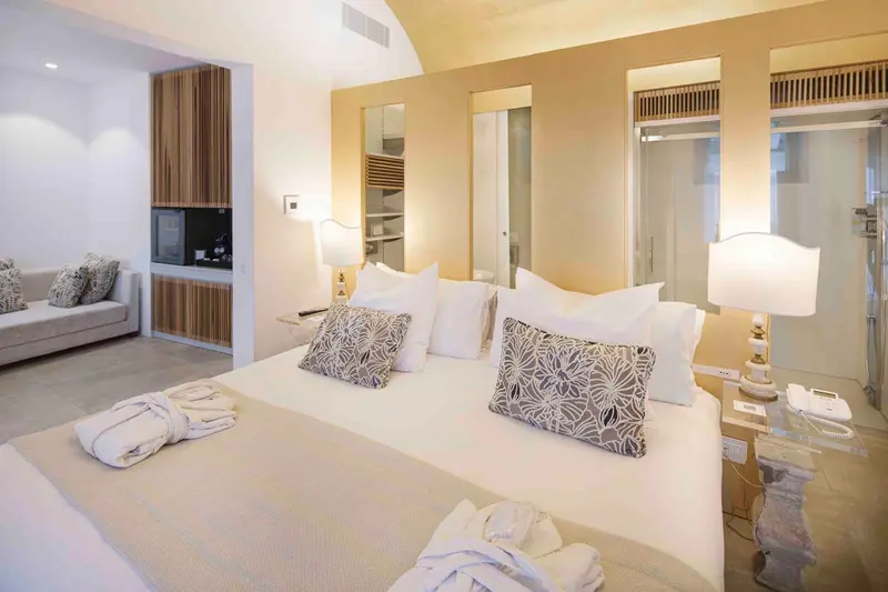 Une chambre lumineuse avec un grand lit et un canapé.