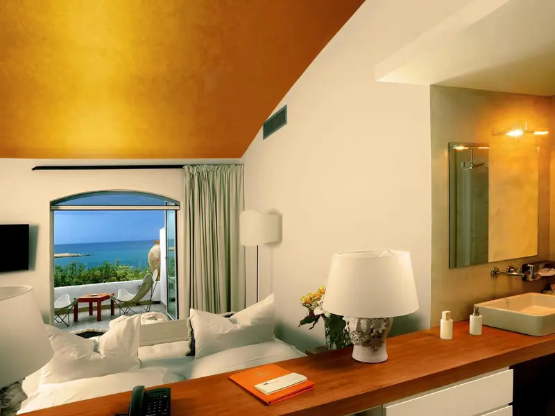 Une chambre lumineuse avec un lit et une vue sur la mer.