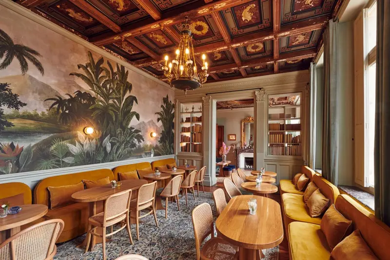 Une salle de restaurant décorée avec des motifs végétaux et un plafond orné.