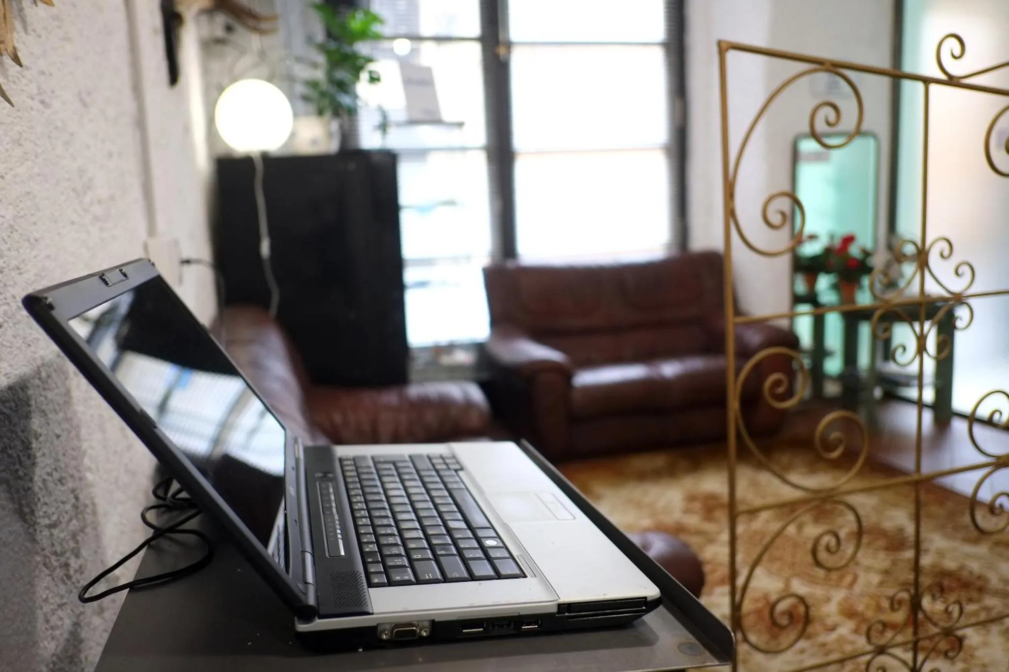 Un ordinateur portable ouvert est posé sur une table basse dans un espace de détente.