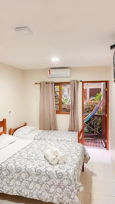 Une chambre lumineuse avec un lit double et un accès à une terrasse.