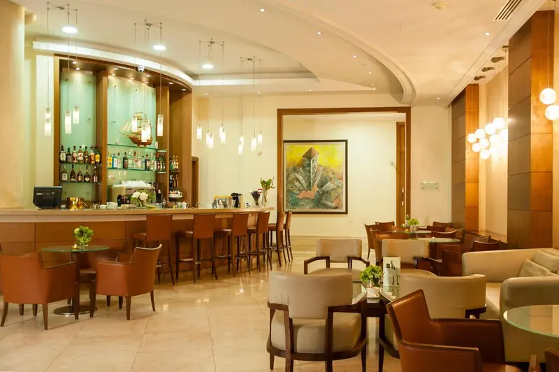 Un bar lumineux avec un comptoir et des tables.