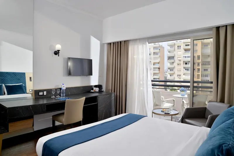 Une chambre d'hôtel moderne avec un lit et un bureau donnant sur un balcon.
