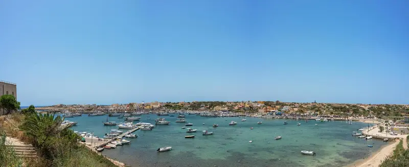 Vue panoramique sur une baie abritée avec de nombreux bateaux amarrés.