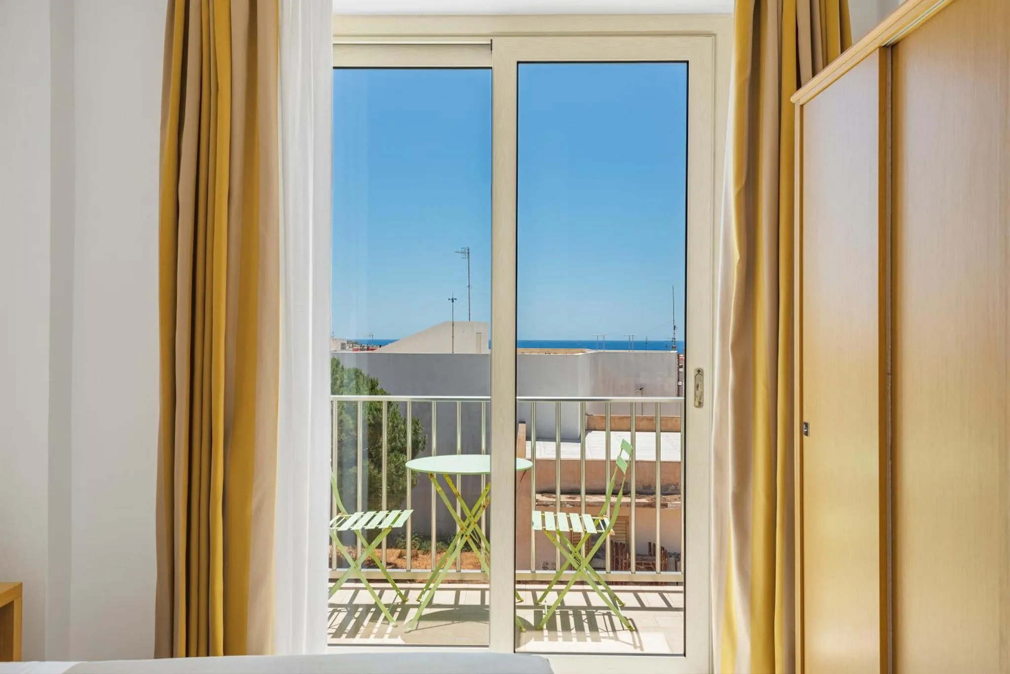 Vue sur la mer depuis une terrasse ensoleillée.