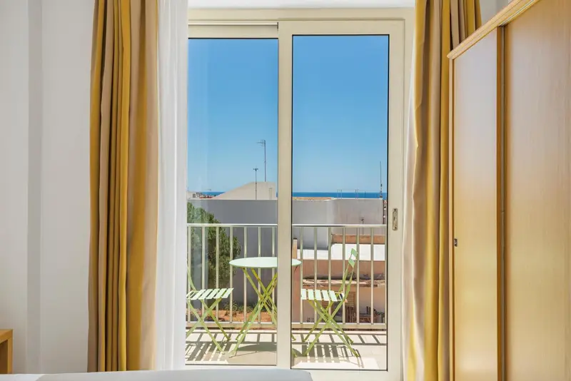Vue sur la mer depuis une terrasse ensoleillée.