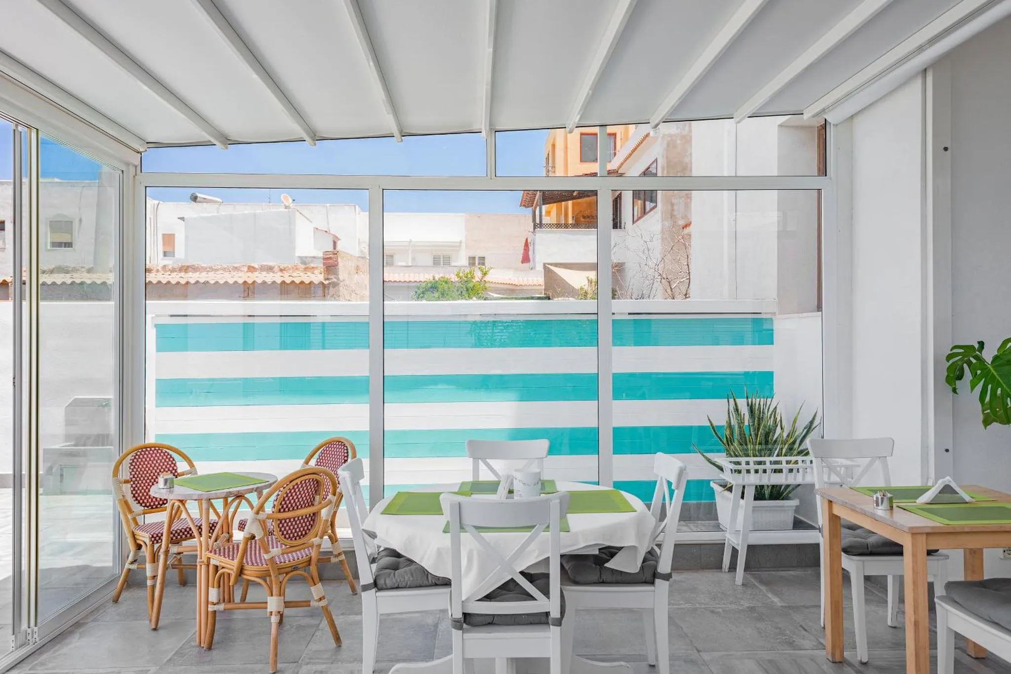 Une salle à manger lumineuse s'ouvre sur une piscine par de grandes baies vitrées.