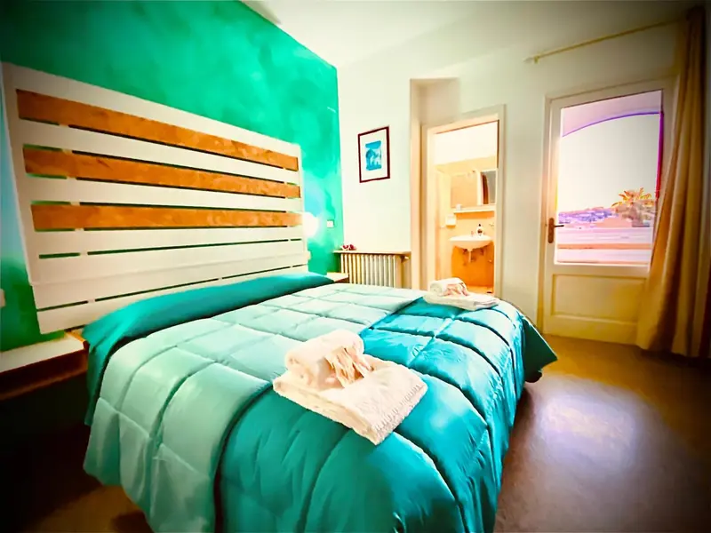 Une chambre à coucher lumineuse avec un grand lit et un accès à une terrasse.