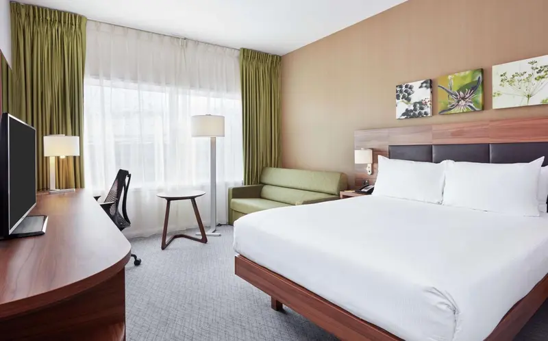 Une chambre d'hôtel lumineuse avec un lit double et un espace détente.