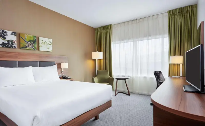 Une chambre d'hôtel lumineuse avec un grand lit et un espace de travail.