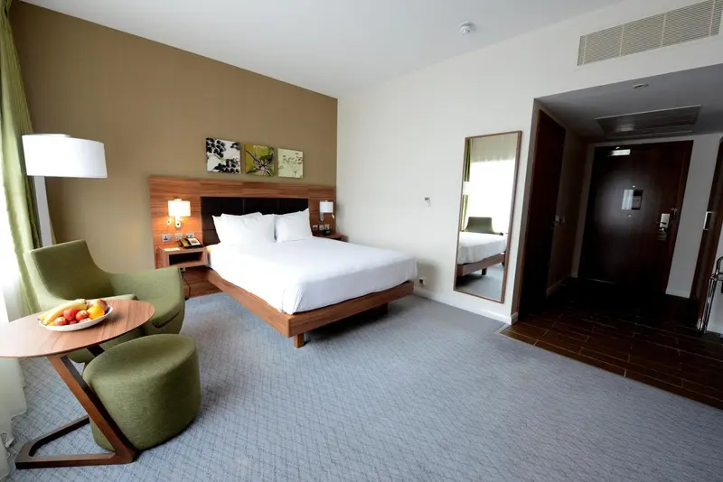 Une chambre d'hôtel lumineuse avec un grand lit et un coin salon.