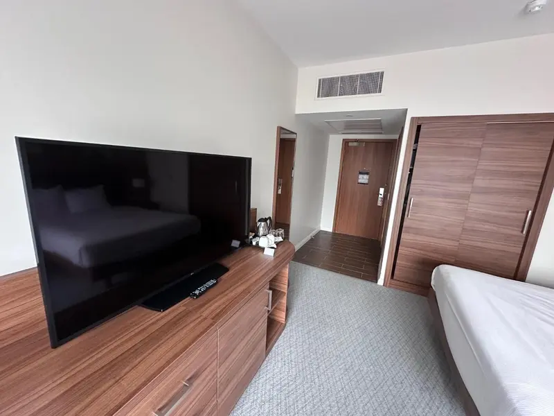 Une télévision est posée sur une commode en bois dans une chambre d'hôtel.