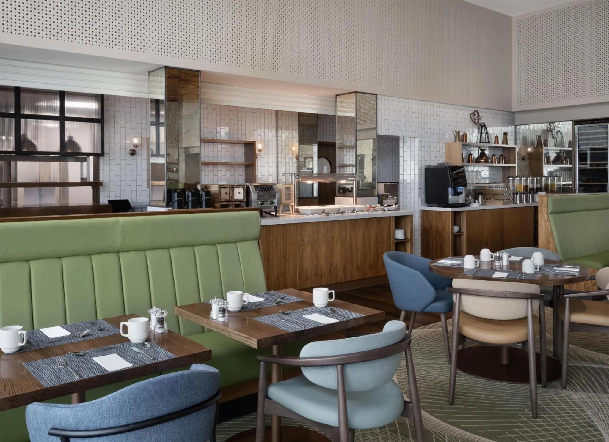 Une salle de restaurant lumineuse avec des tables et des banquettes.