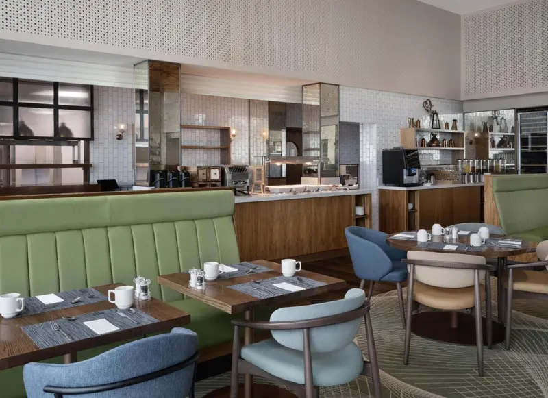 Une salle de restaurant lumineuse avec des tables et des banquettes.