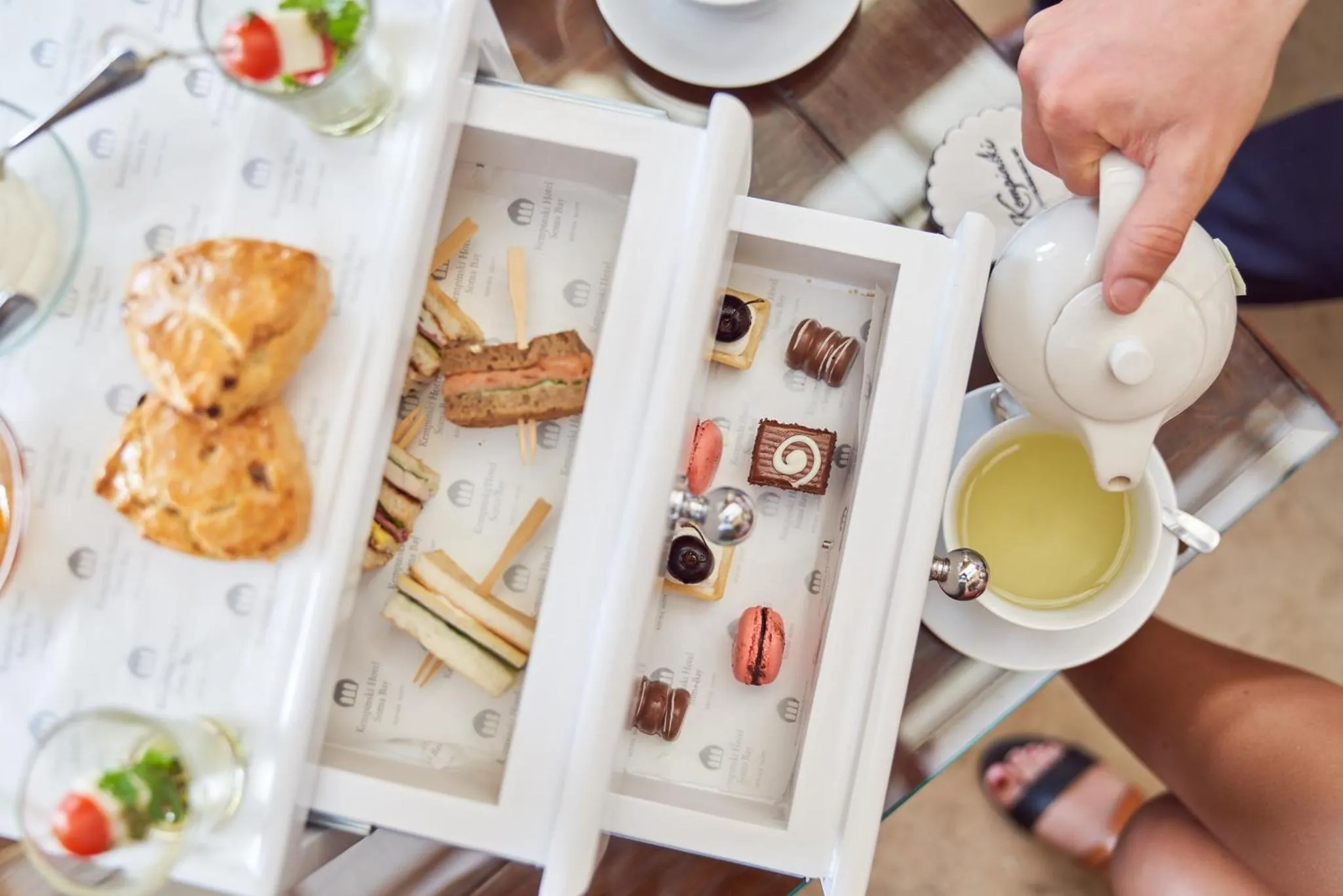 Une table basse présente une sélection de pâtisseries et de thé.