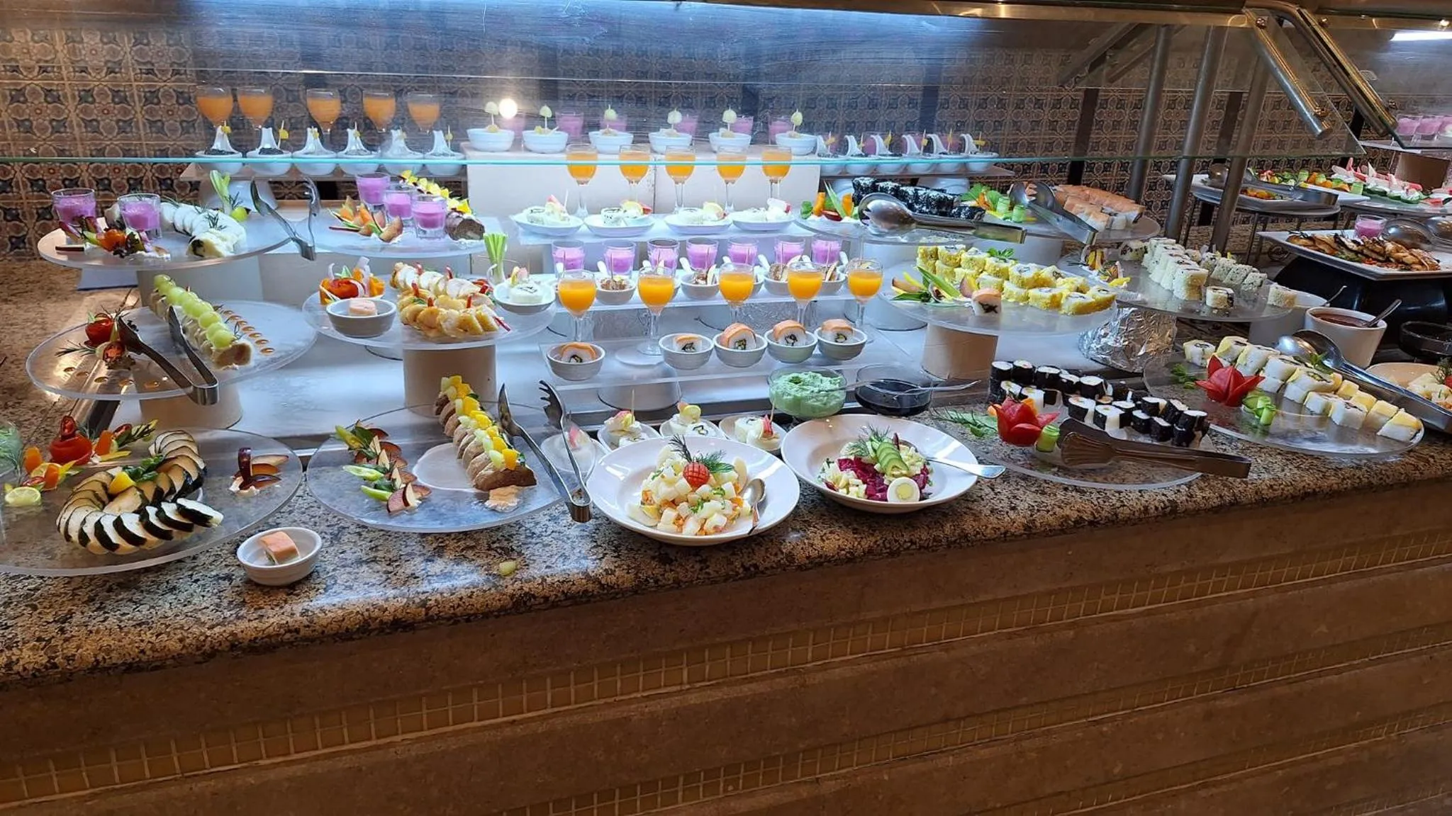 Un buffet propose une grande variété de plats froids et de desserts colorés.