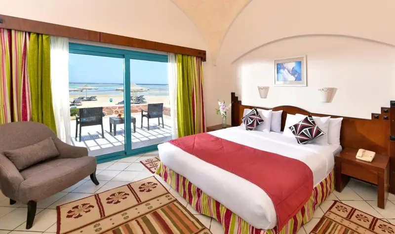 Chambre lumineuse avec un lit double donnant sur une vue mer.