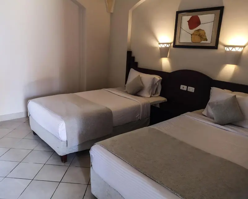 Une chambre avec deux lits simples et une décoration murale.