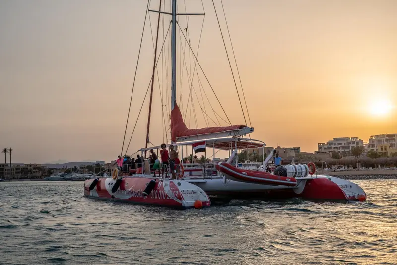 Un catamaran amarré sur l'eau au coucher du soleil.