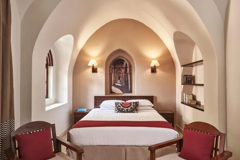 Une chambre à coucher avec un lit double et des murs aux arches.