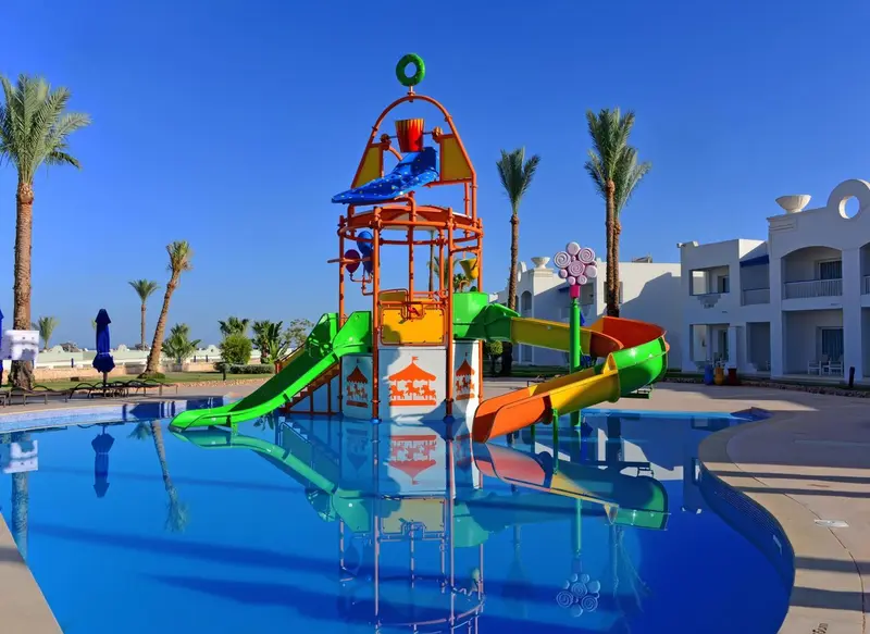 Structure de jeux aquatiques colorée au bord d'une piscine ensoleillée.