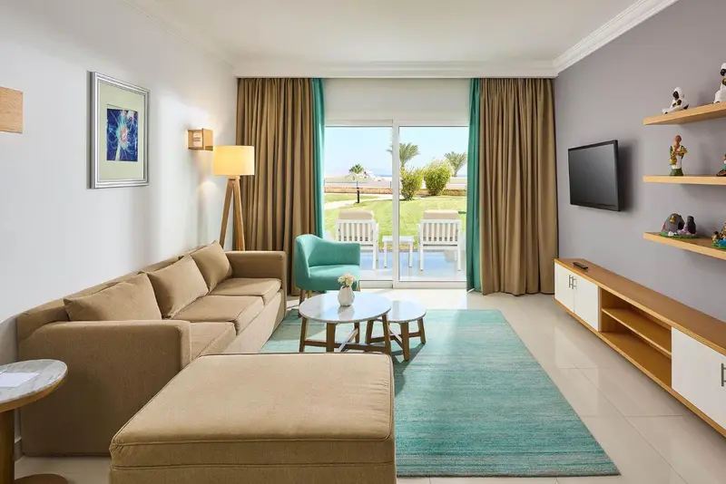 Espace de détente lumineux avec canapé, table basse et accès à une terrasse.