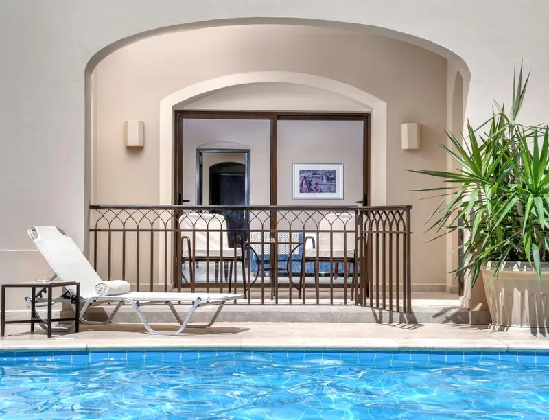 Terrasse avec transat donnant sur une piscine et un espace aménagé.