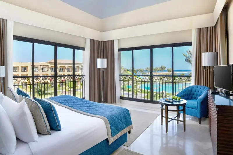 Une chambre lumineuse avec un grand lit et une vue sur la mer.