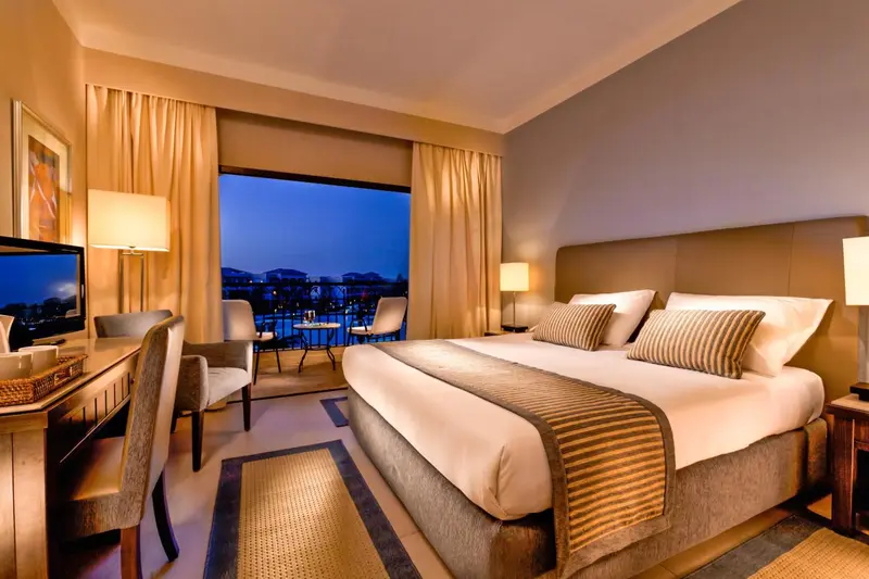 Une chambre lumineuse avec un grand lit et une vue sur la mer.