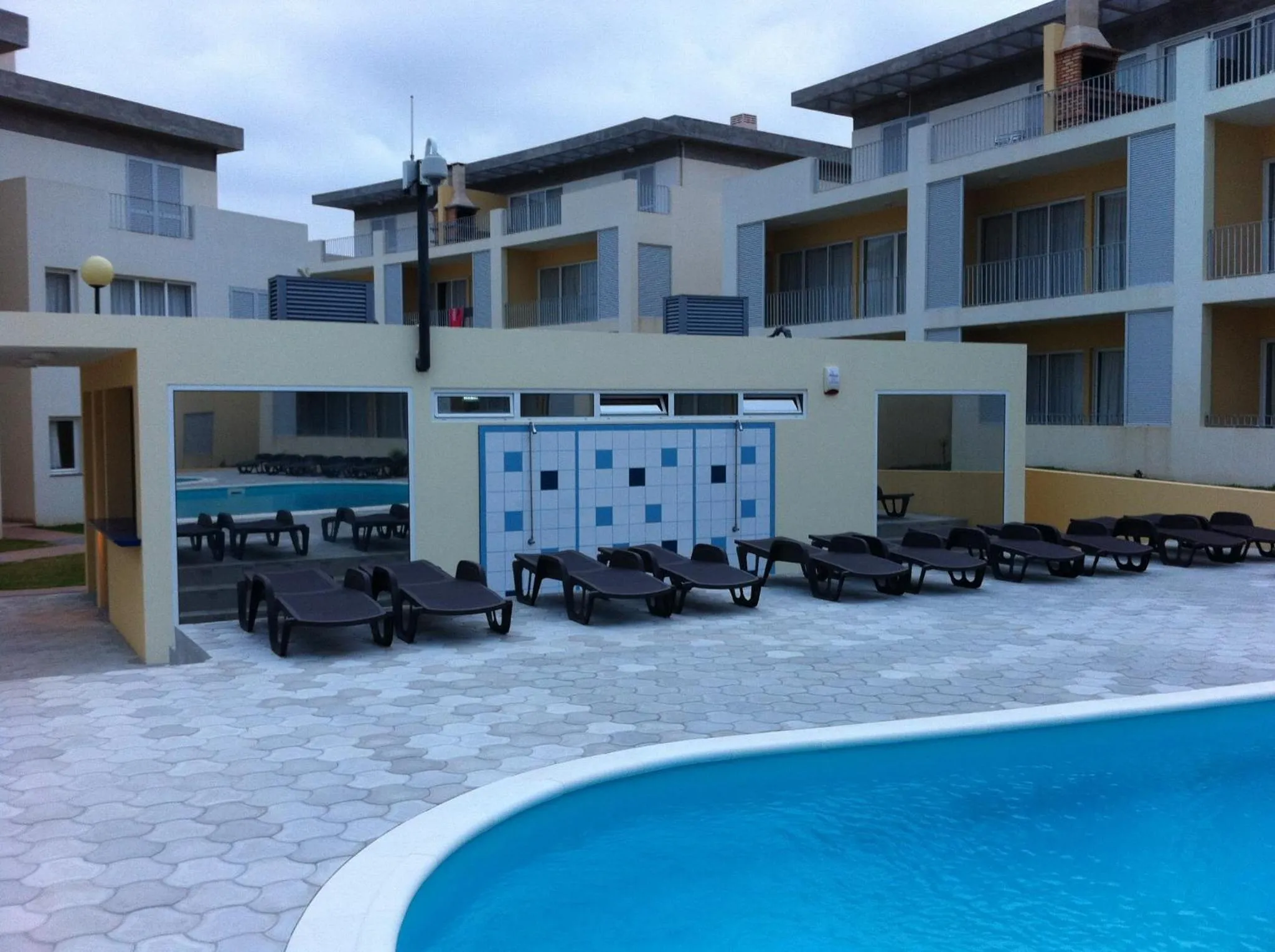 Transats alignés au bord d'une piscine dans un complexe hôtelier.