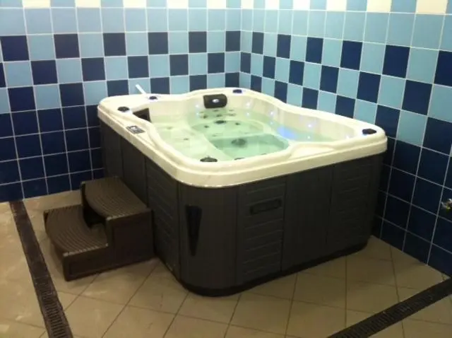 Un jacuzzi encastré dans une salle de bain carrelée.