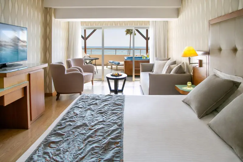 Une chambre lumineuse avec un espace salon et une vue sur la mer.