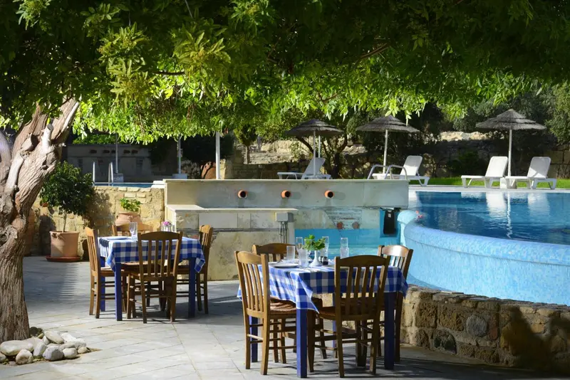 Tables dressées à l'extérieur près d'une piscine ensoleillée.