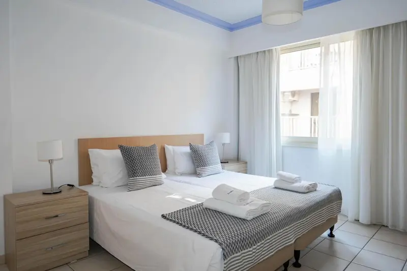 Une chambre lumineuse avec un grand lit et des tables de chevet.