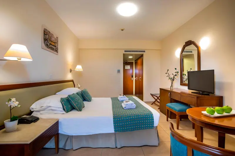 Une chambre lumineuse avec un grand lit et une décoration sobre.