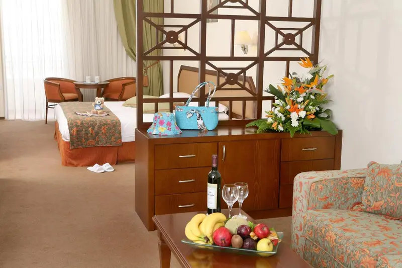 Une chambre lumineuse avec un lit, un coin salon et une décoration florale.
