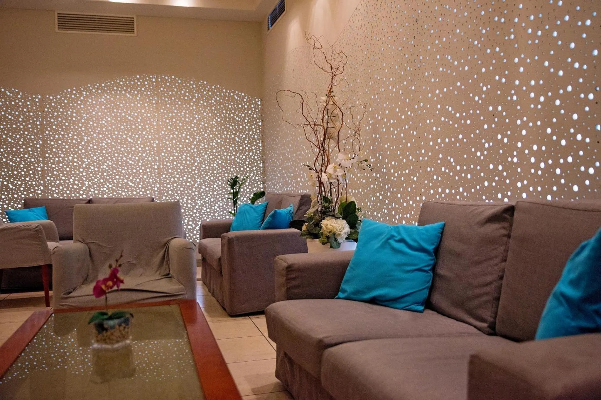 Espace de détente avec canapés et décoration florale.