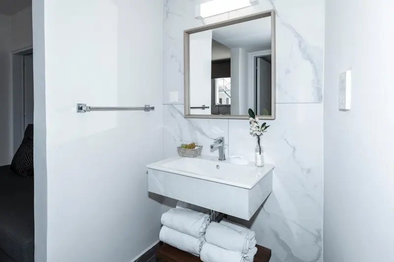 Une salle de bain moderne avec un lavabo et des serviettes.
