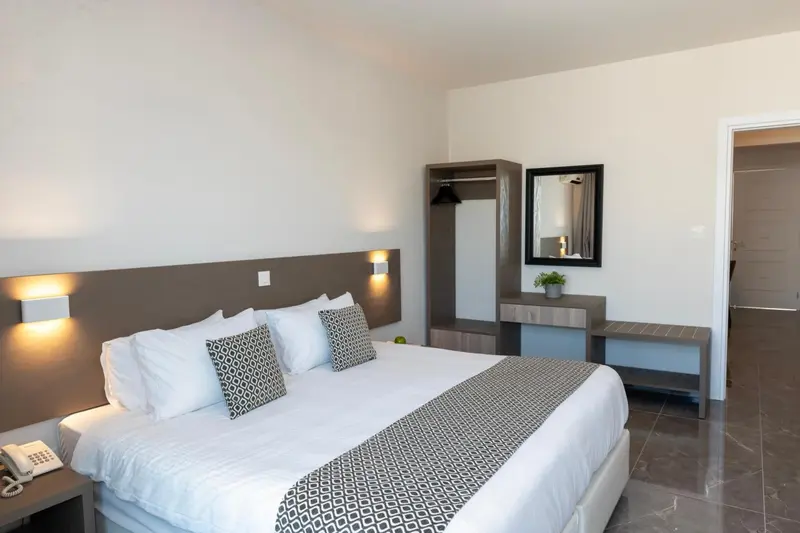 Une chambre lumineuse avec un grand lit et une décoration sobre.